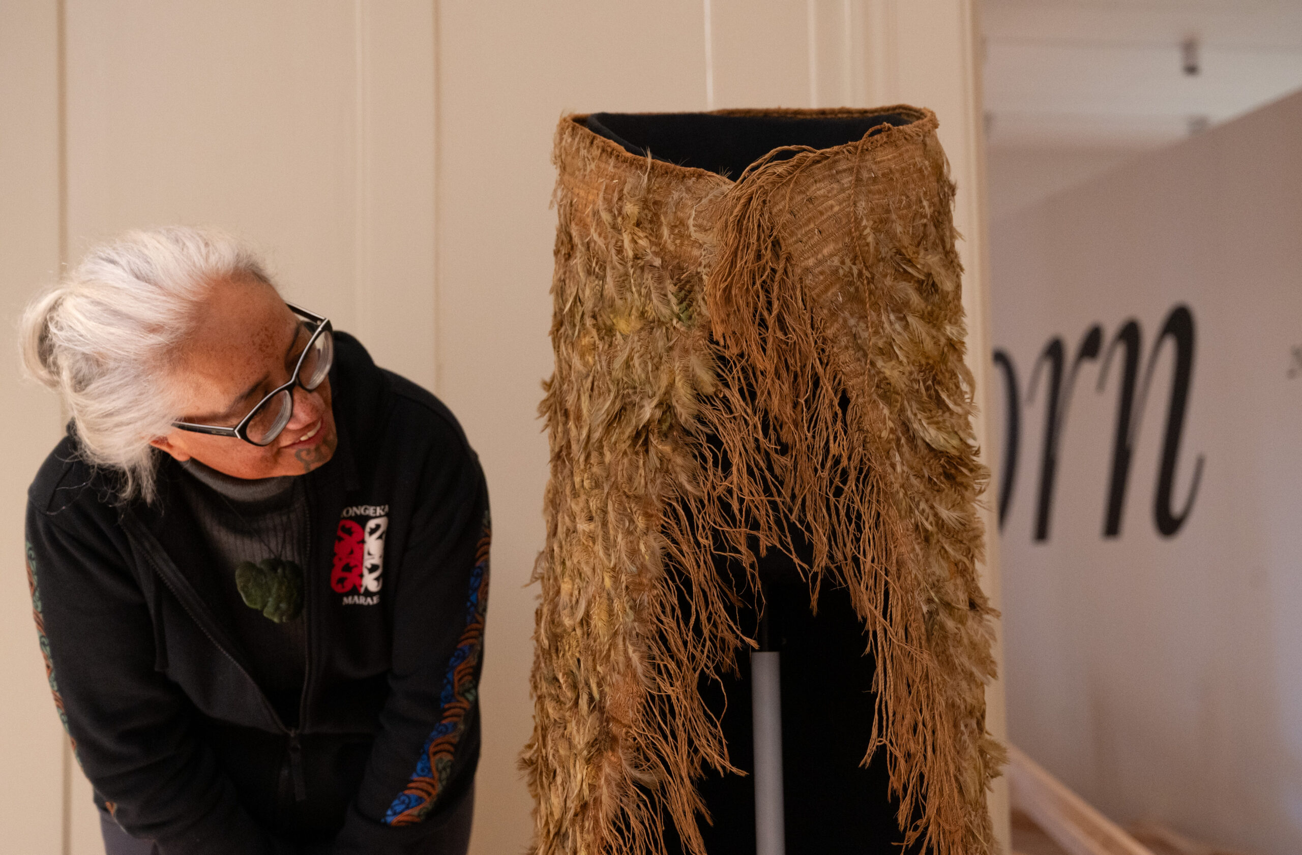 Awhina Tamarapa looking at the Kahu Kākāpō cloak