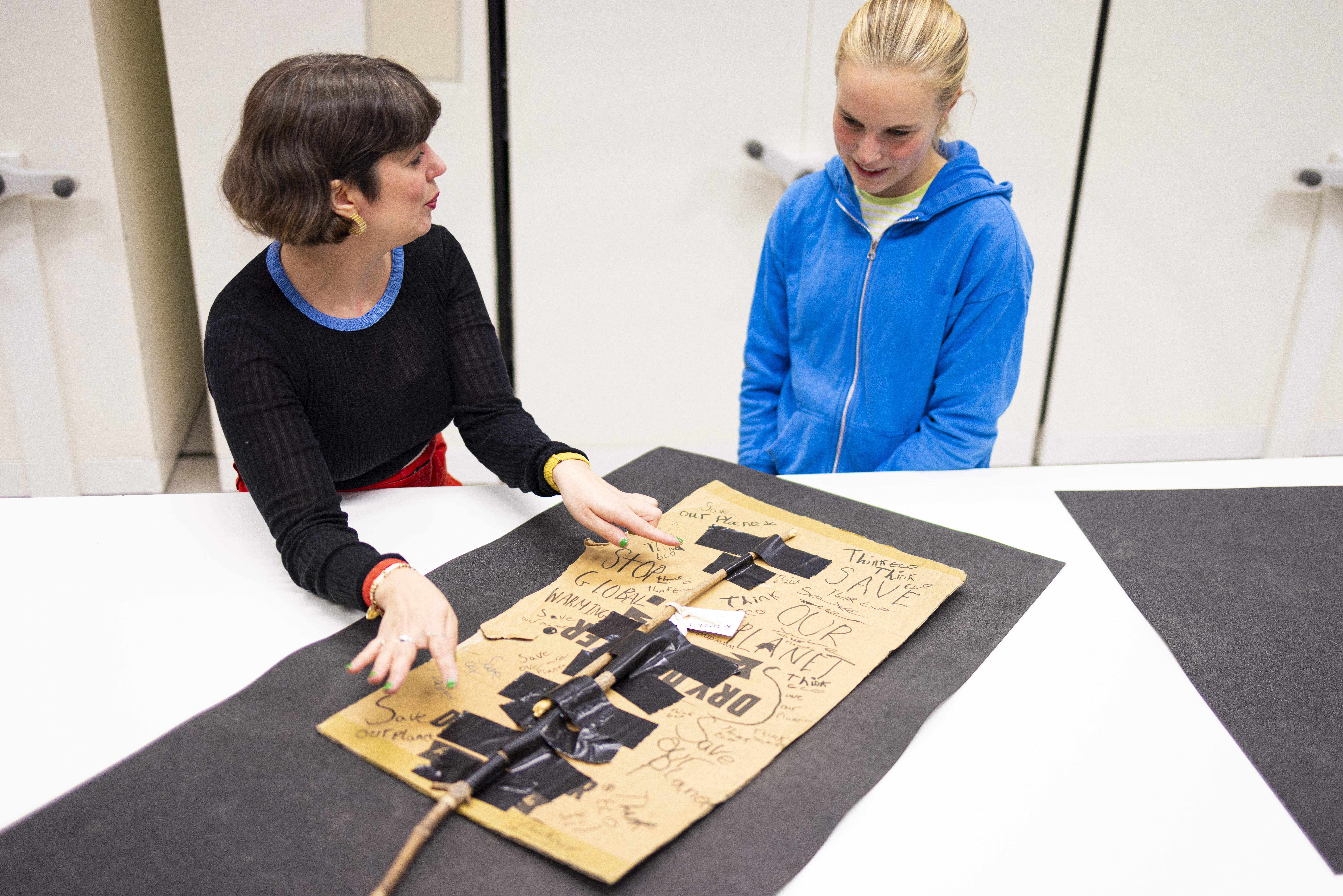 Bridget tells Curator Mhairi Maxwell about her climate protest placard at the National Museums Collection Centre. Photo © Duncan McGlynn